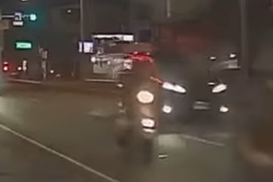 鳳梨遭到畫面中一名騎乘白色機車的不明男子尾隨並開槍。(圖/翻攝自記者爆料網)