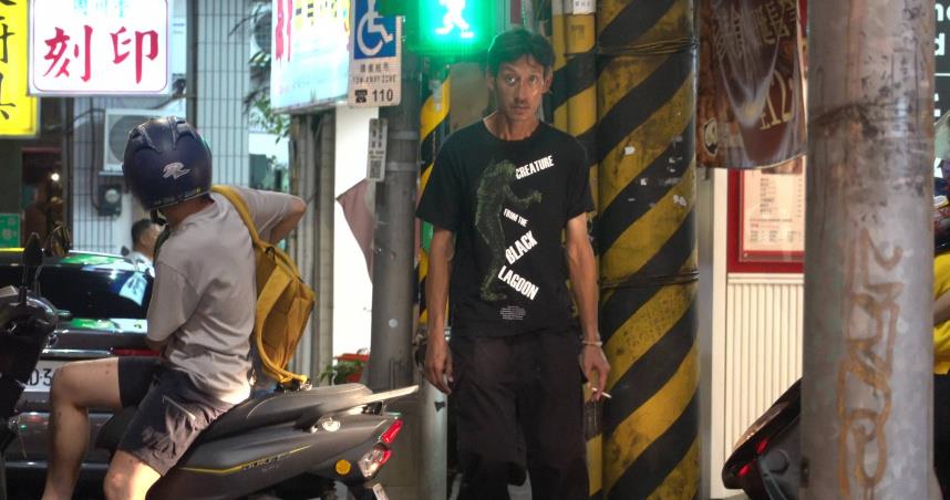 唐治平在南港附近的捷運站綠地緩緩繞圈散步，面無表情且動向隨意不定。（圖／CTWANT提供）