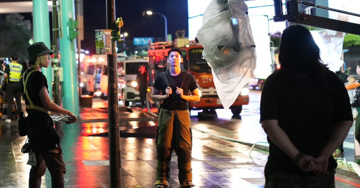 電影《96分鐘》男主角林柏宏（中）於信義區松壽路道路管制與攝影機確認拍攝位置。（圖／台北市電影委員會）