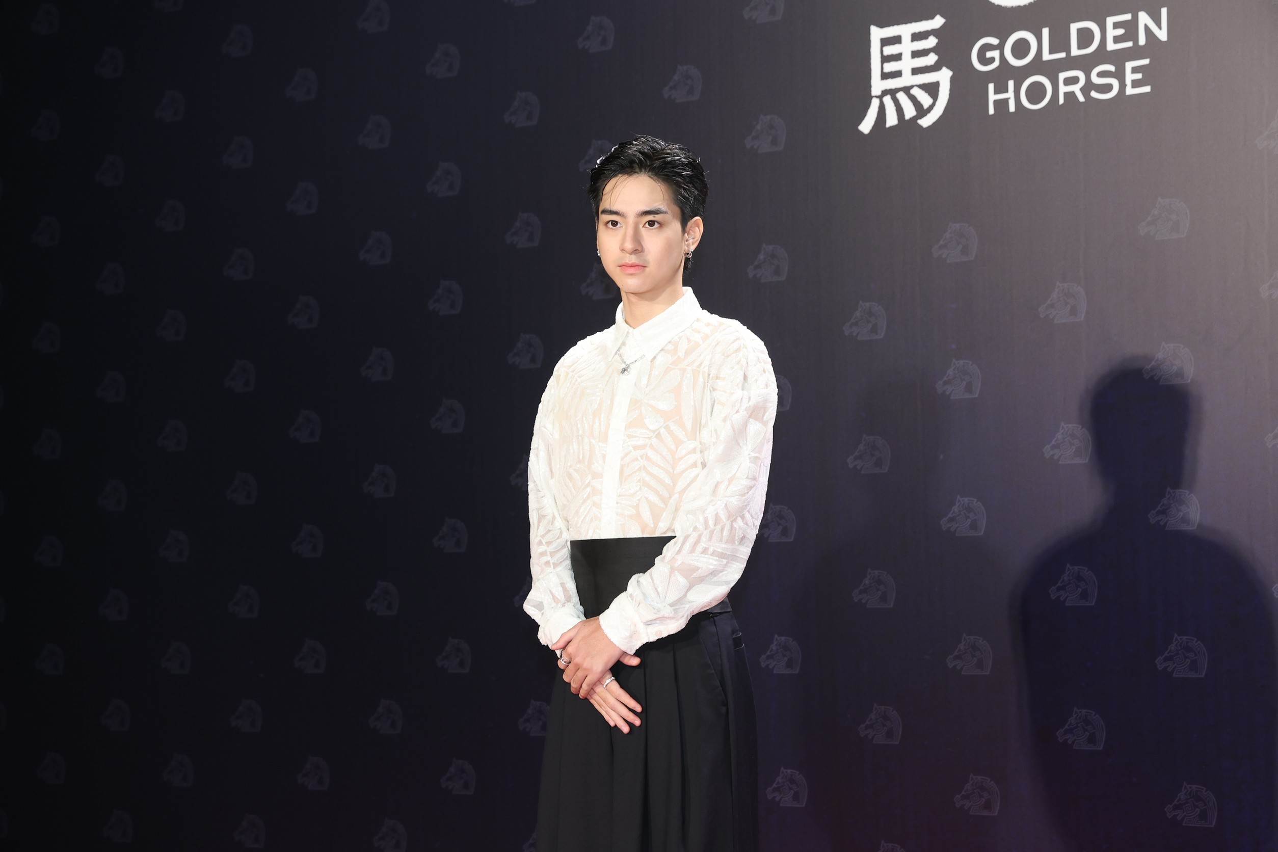 劉敬以白色紋路透膚襯衫搭配黑色寬褲，整體造型俐落又成熟。（圖／東森新聞）