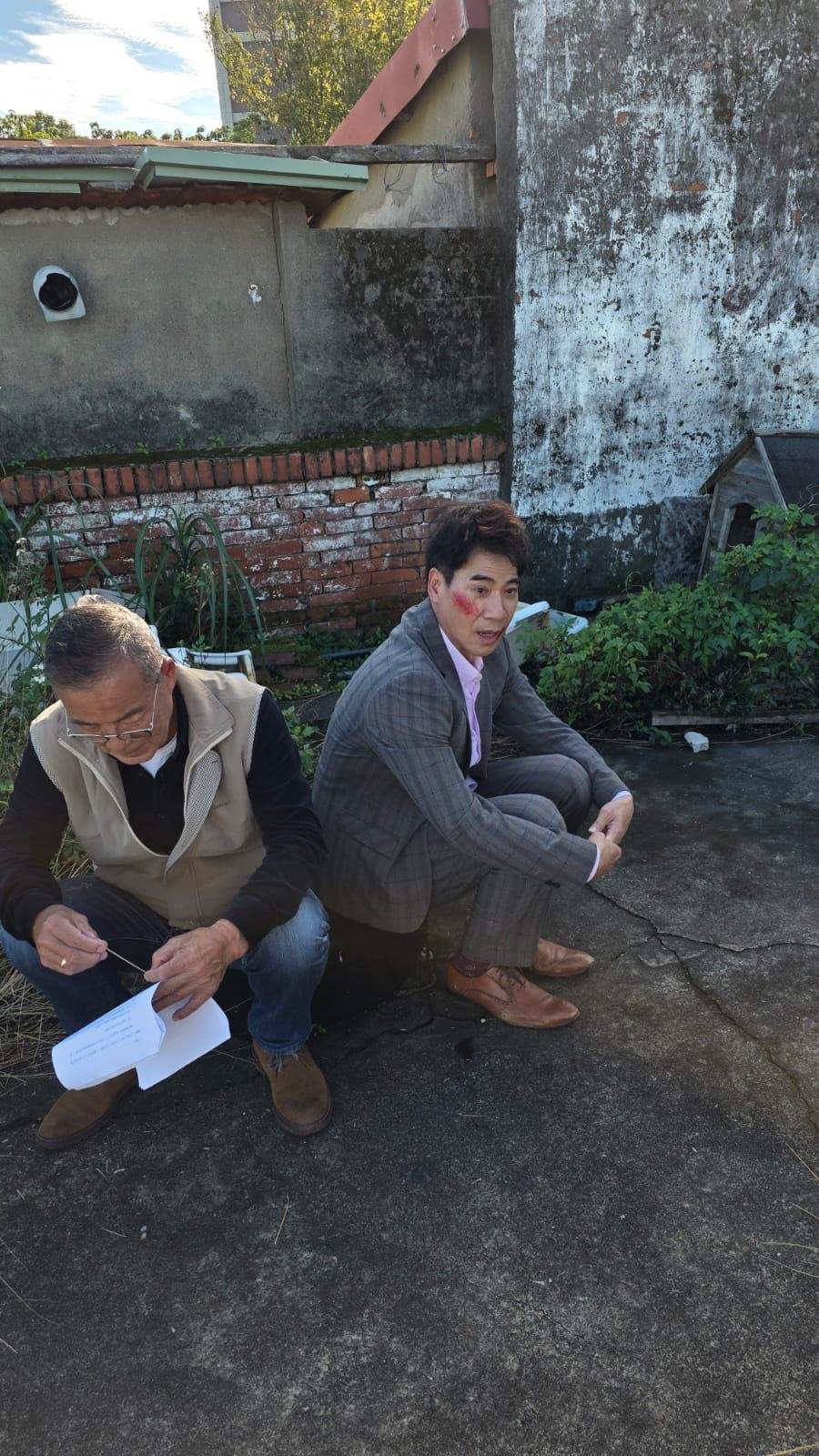 翁家明（右）拍攝打鬥戲後，服裝、鞋子滿是磨痕，與龍天翔（左）在一旁休息。（圖／民視）