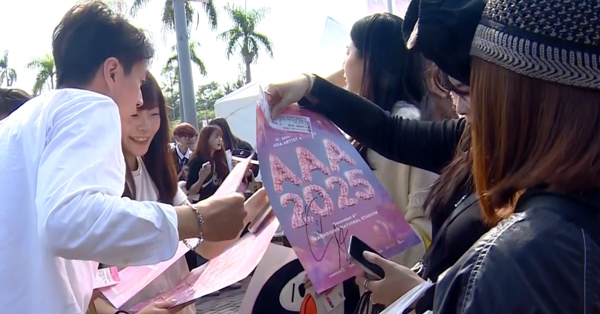 粉絲們圍成一圈開小組會議，討論海報上簽名是誰的。（圖／東森新聞）