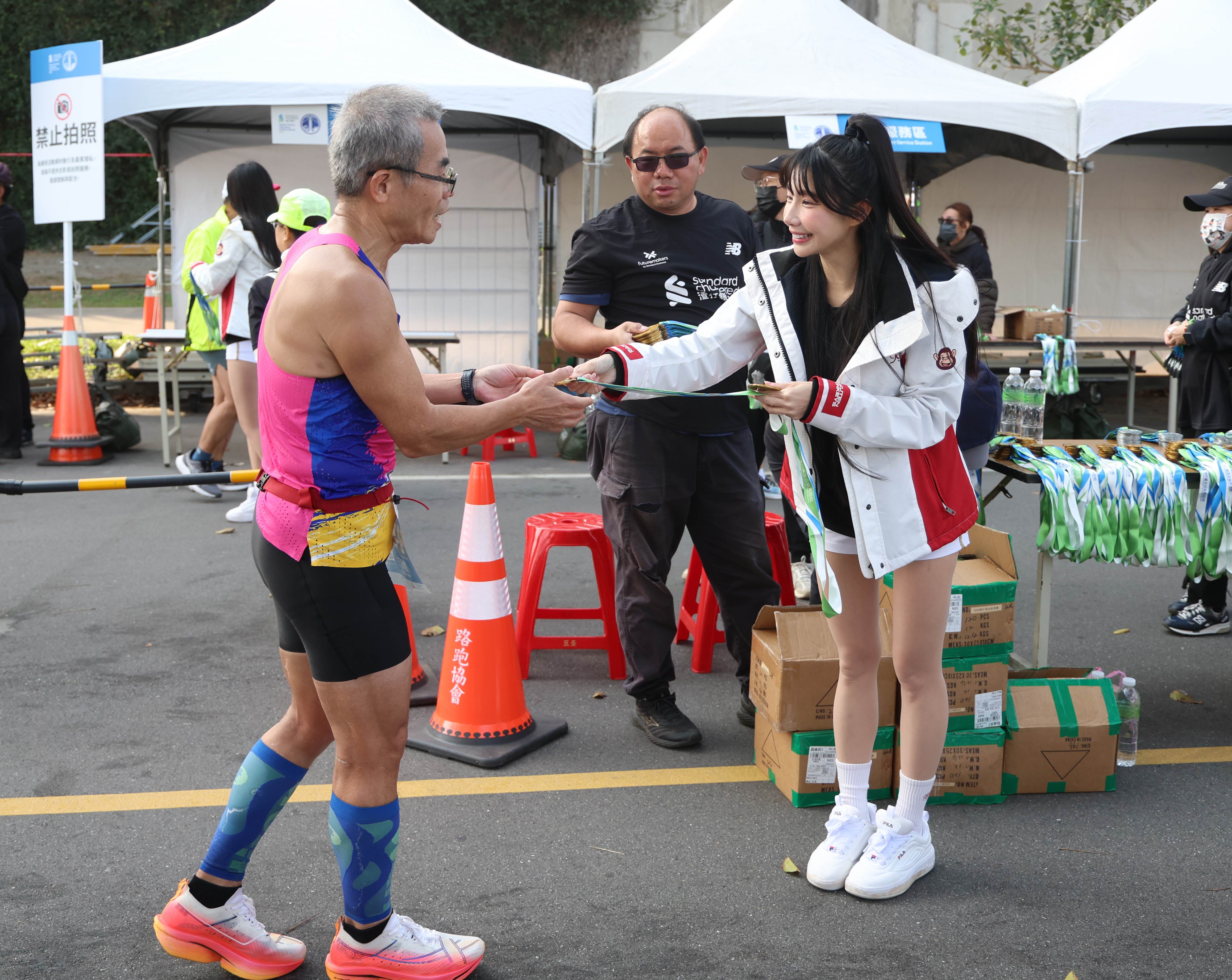 筠熹終點站給跑者獎牌。（圖／樂天桃猿提供）