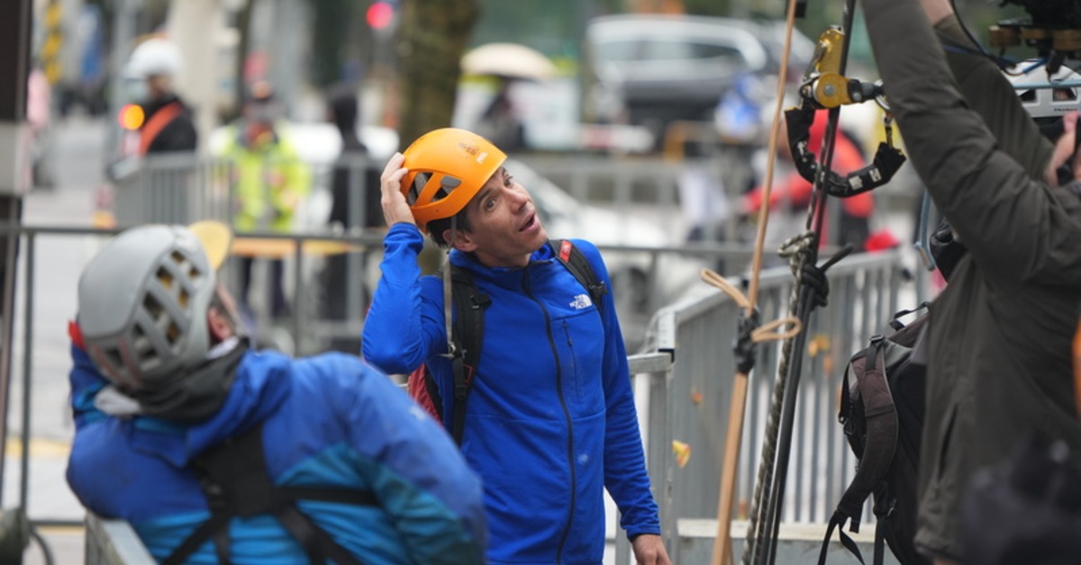 霍諾德（中）21日進行雨天試爬前與團隊交換意見。（圖／中央社）