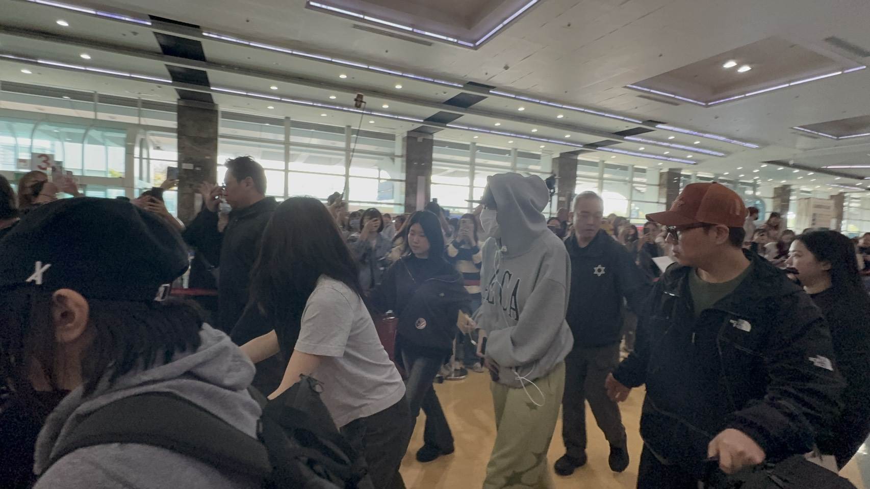 韓國歌手李泳知穿著灰色帽T、卡其色褲子和拖鞋現身接機大廳，幫粉絲簽名約10分鐘才離開。（圖／記者楊雅芸攝）