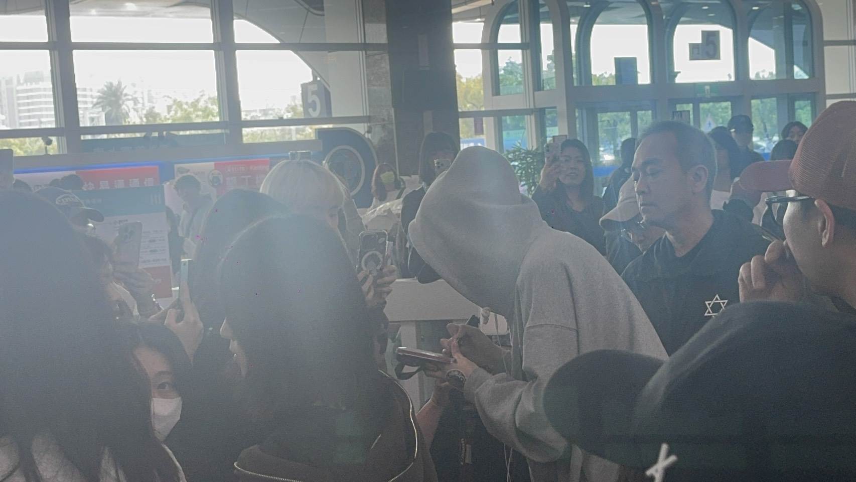 韓國歌手李泳知穿著灰色帽T、卡其色褲子和拖鞋現身接機大廳，幫粉絲簽名約10分鐘才離開。（圖／記者楊雅芸攝）