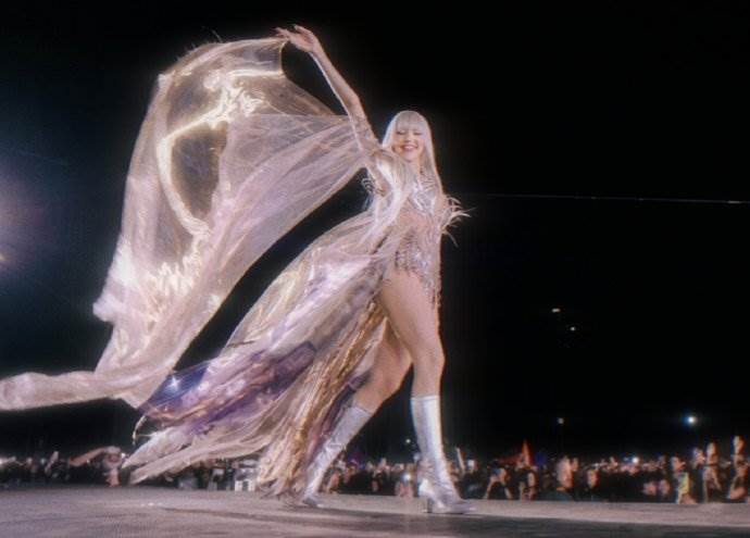 南韓女團BLACKPINK成員Lisa戴著白色假髮，身穿金屬感材質的馬甲禮服搭配薄紗披風。（圖／翻攝自Coachella YouTube）