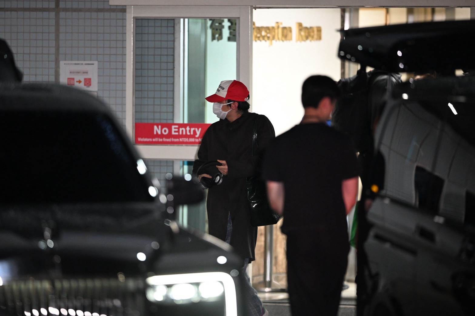 南韓男神GD（G-Dragon，權志龍）頭戴紅色帽子、身穿長版黑色外套現身小港機場。（圖／讀者提供）