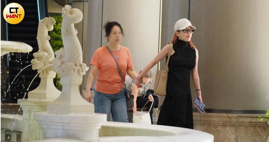 温嵐身著一身黑色無袖連身長裙、戴著白色帽子及黑框眼鏡，在母親陪同下現身台北信義區五星級飯店大廳，整體氣色看來不錯，但仍略顯虛弱。（圖／CTWAN）