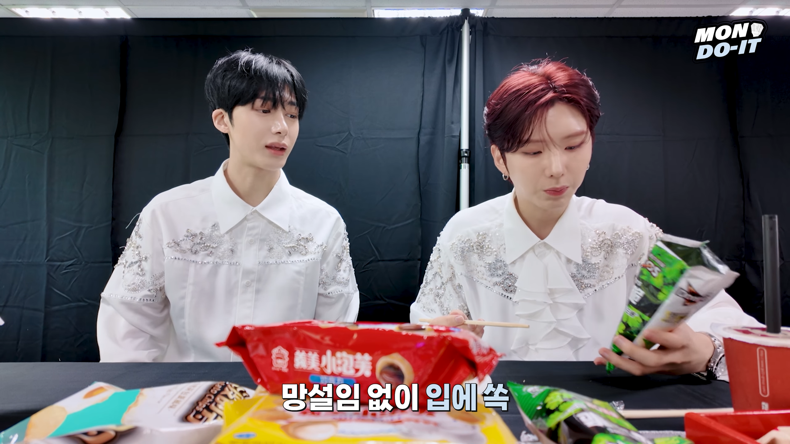 兩人品嘗香菜口味多力多滋。（圖／翻攝自MONSTA X YouTube頻道）